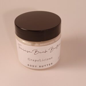 Clear jar with black lid and ThereseBeah Butters logo white label. The scent is saying GrapeLicious