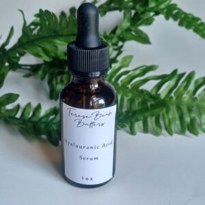 Amber glass bottle with black rubber topper, white label reads Theresebeah Butters hyalauronic acid serum, 1 oz